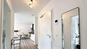 Eine moderne Wohnung mit Küche, Essbereich und einem großen Spiegel.