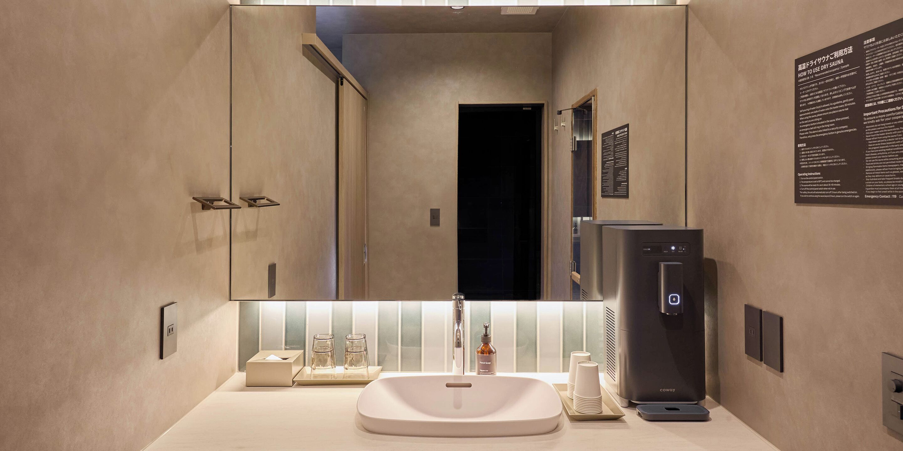 A modern bathroom with a large mirror, a sink, and a shower area.