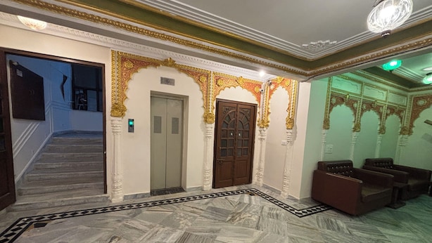 A lobby with marble flooring, a staircase, and a reception area with seating. - Hotel Royale Plazo (Jodhpur)