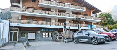 Un immeuble à plusieurs étages, doté d’une façade en bois, de balcons et d’une enseigne indiquant « alp real estate ».