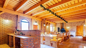 A rustic kitchen with a brick fireplace, wooden beams, and a tiled floor. - Beautiful private villa for 10 people with WIFI, private pool, terrace and pets allowed (Lesní Chalupy)