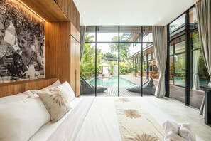 A bedroom with a large bed, a view of a swimming pool, and a mural on the wall. - Exquisite 6-bedroom Retreat, Moments to Beach (Seminyak)