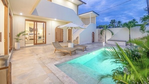 A modern house with a swimming pool, two lounge chairs, and a staircase leading to the upper floor. - Chic Villa Living, Hidden Serenity of Canggu (Canggu)