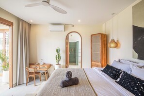 A bedroom with a bed, a desk, a chair, a potted plant, and a wardrobe. - 4BR Tropical Retreat With Private Pool Near Canggu (Canggu)