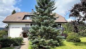 Une maison appelée Haus Rotdorn, dotée d’un toit en pente, de panneaux solaires et d’un jardin bien entretenu.