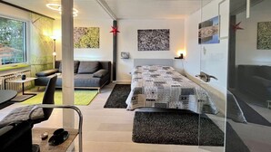 Une chambre à coucher moderne avec un lit, un canapé, un bureau et une chaise.