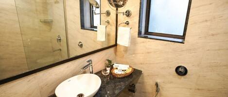 A modern bathroom with a large mirror, a sink, and a toilet.