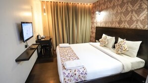 A hotel room with a large bed, a desk with a computer, and a TV. - Hotel Singh's Vashi Navi Mumbai (Navi Mumbai)