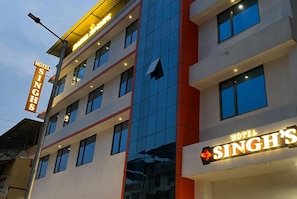 Monikerroksinen hotellirakennus, jonka julkisivussa on suuri, huomiota herättävä kyltti, jossa lukee: ”HOTEL SINGH’S”.