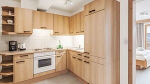 Une cuisine moderne avec des meubles en bois, un four encastré et un évier.