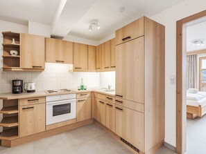 Eine moderne Küche mit Holzausstattung, einem eingebauten Ofen und einem Spülbecken.