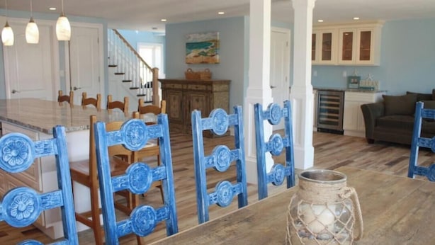 Un comedor con una mesa de madera, sillas azules y una lámpara colgante.