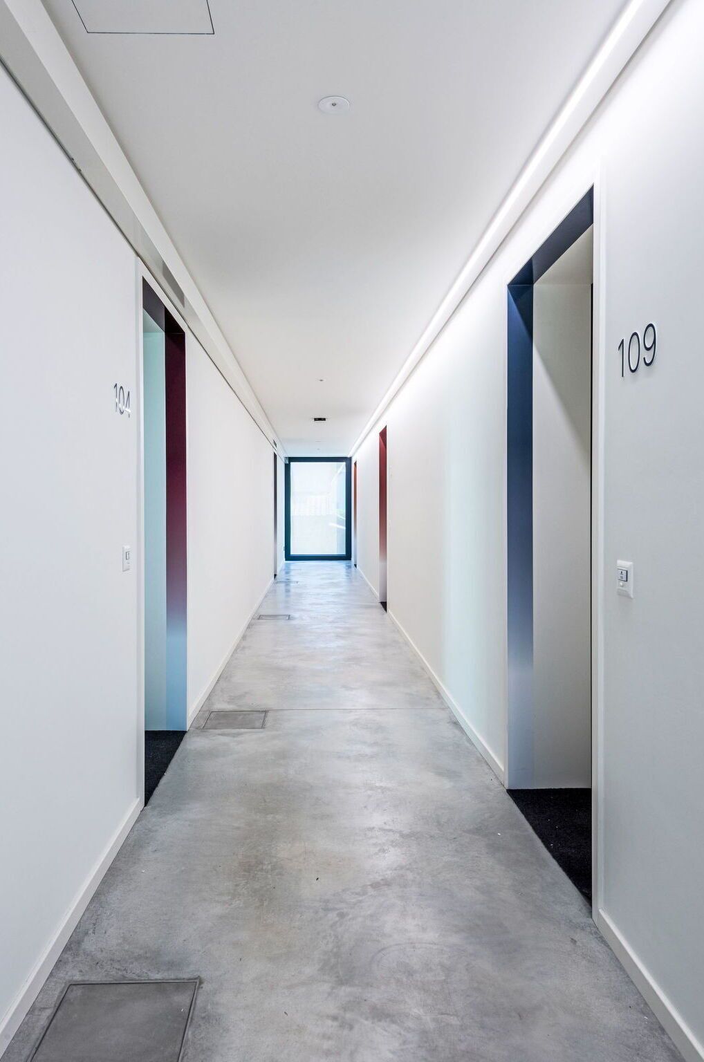 A long, narrow hallway with doors numbered 104 and 109, leading to rooms.