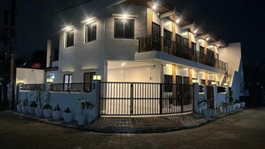 Una casa moderna de dos pisos con entrada protegida y plantas en macetas.