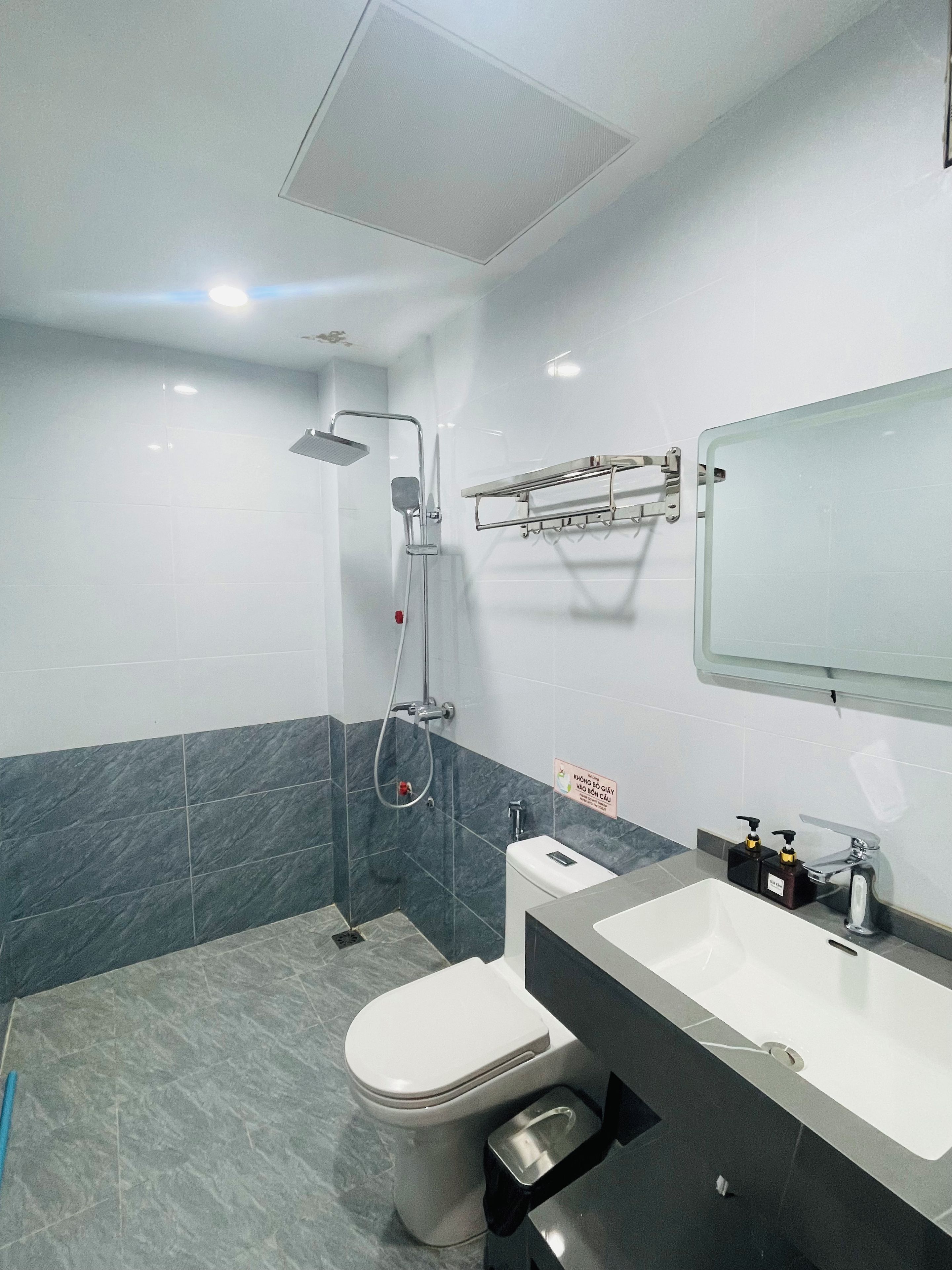 A modern bathroom with a shower, toilet, and sink.