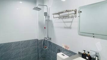 A modern bathroom with a shower, toilet, and sink.