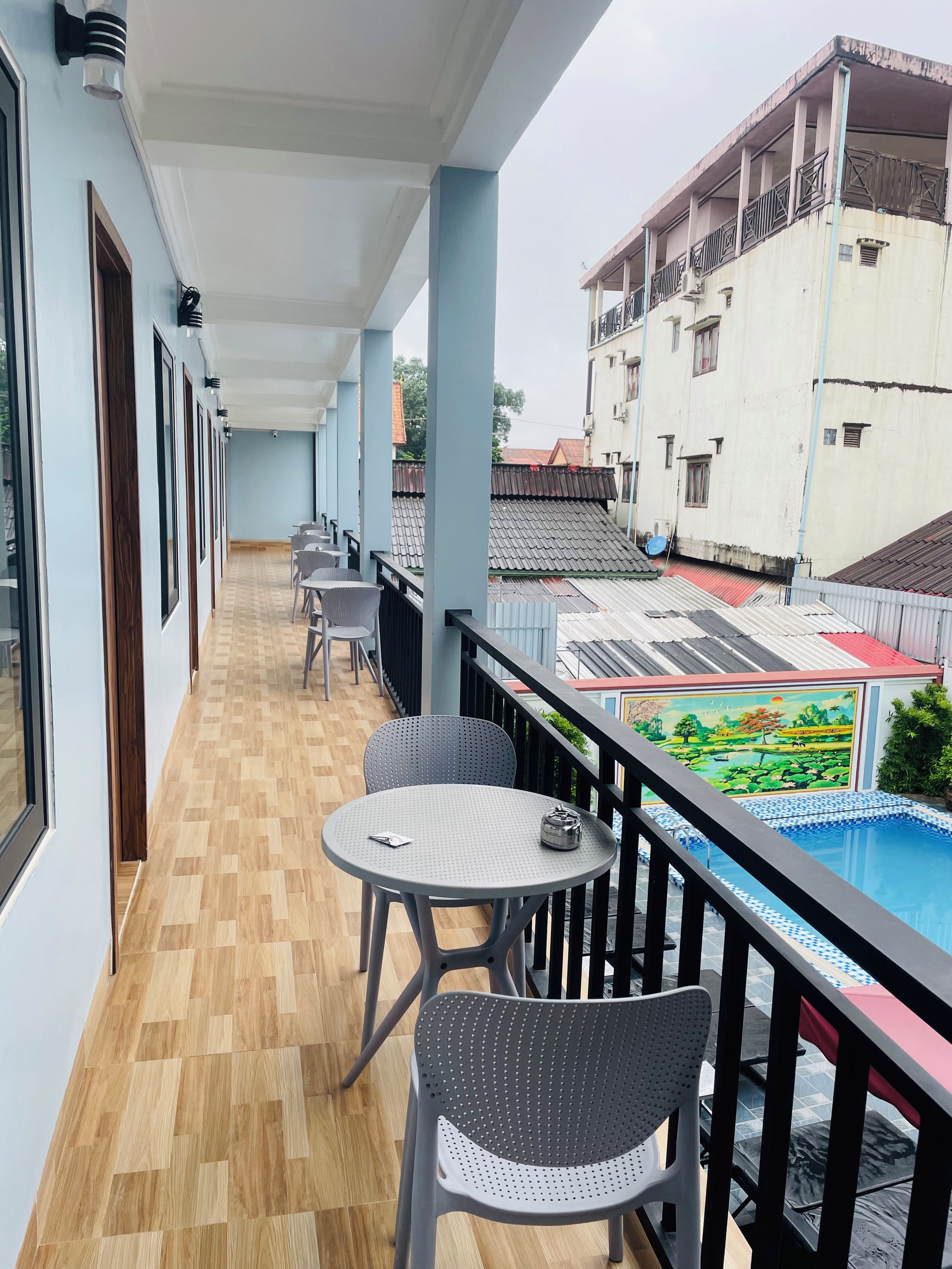 Varanda com piscina, piso de madeira e área de estar.