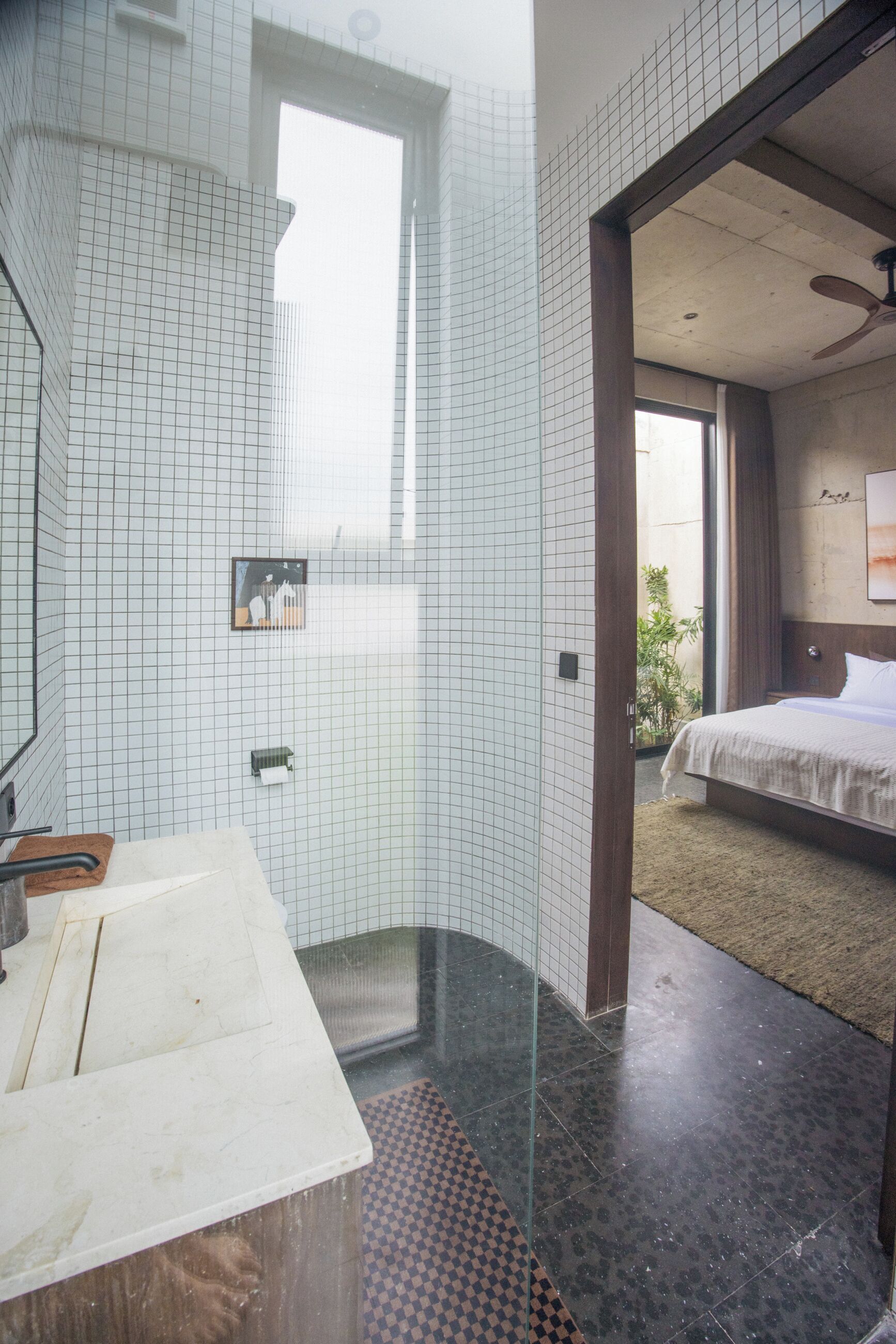 A modern bathroom with a large mirror, a wooden countertop, and a shower area.