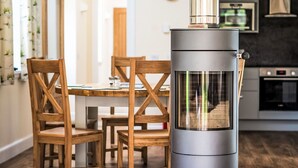 Une cuisine moderne avec un poêle à bois, des chaises en bois et une table à manger.