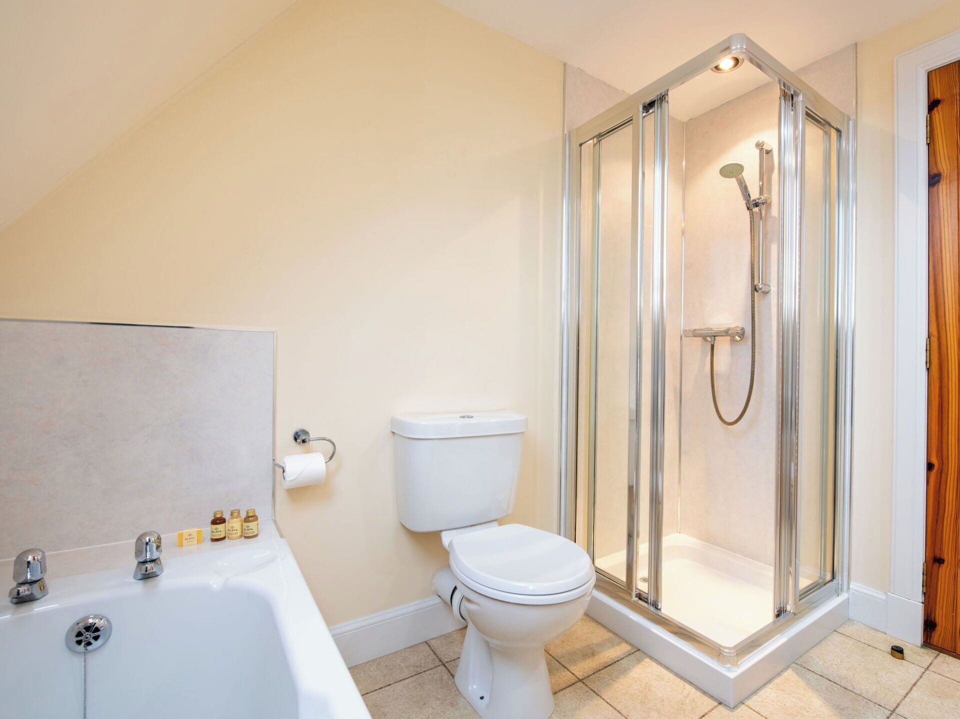 A bathroom with a toilet, a bathtub, and a glass-enclosed shower area.