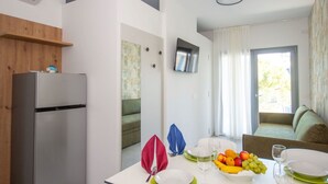 Una cocina moderna con un refrigerador empotrado, una mesa de comedor dispuesta con platos, vasos y fruta.