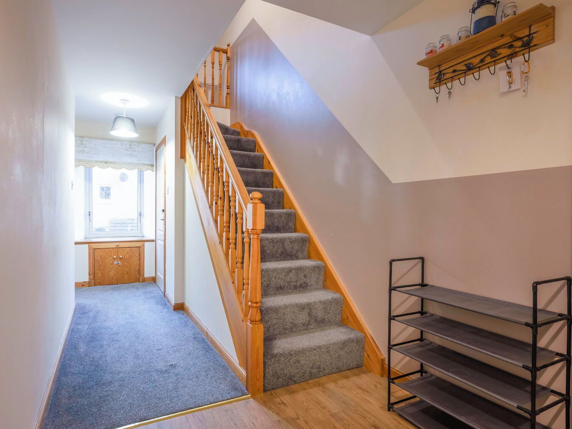 A staircase with wooden railings and carpeted steps leading to a landing.