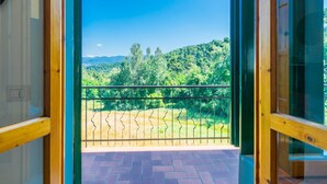 Un balcón con vistas a un paisaje verde y montañas.