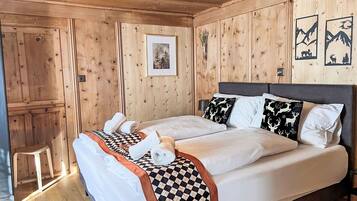 Ein Zimmer mit Holzwänden, einem Bett, Kissen und einem gerahmten Bild an der Wand.