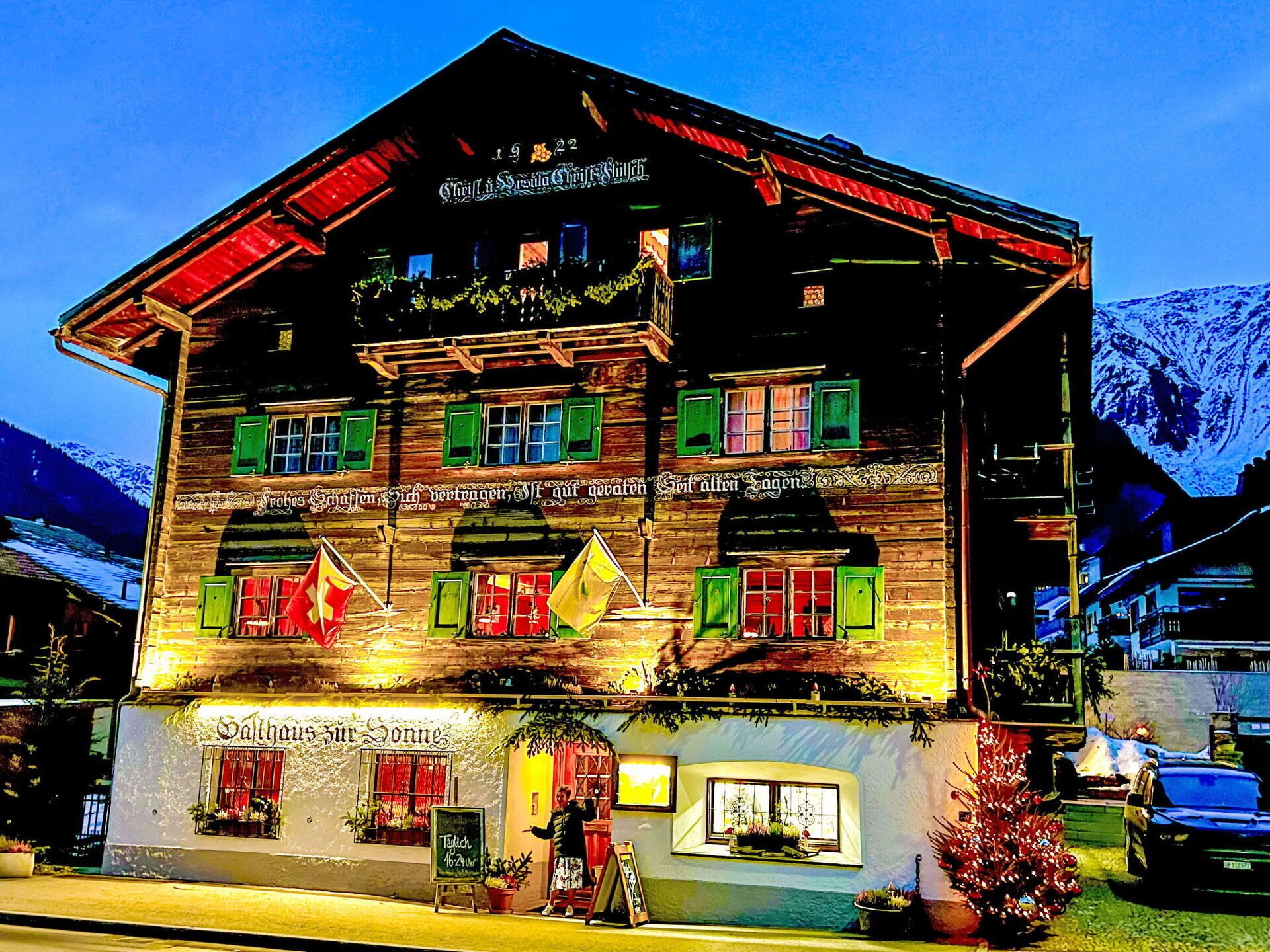 Ein traditionelles Holzhaus mit mehreren Fenstern und einem Schild, das es als Restaurant kennzeichnet.