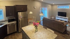 A modern kitchen with granite countertops, stainless steel appliances, and pendant lighting. - The Nook at Latimer - 2 Bedroom Carriage House- Short Walk to Downtown and Beach (Penticton)