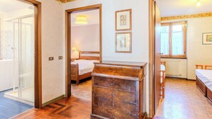 Ein Hotelzimmer mit einem Holzkapfen, einem Bett, einem Heizkörper und einem Fenster.