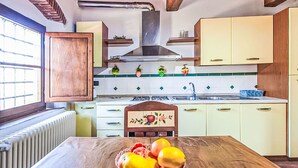 Una cocina con armarios de madera, una isla central y un cuenco de frutas.