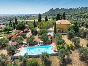 A pool area with a clear view of the surrounding landscape, including a hill with trees and a distant castle. - Beautiful apartment for 5 guests with A/C, WIFI, pool, patio and pets allowed (Campiglia Marittima)
