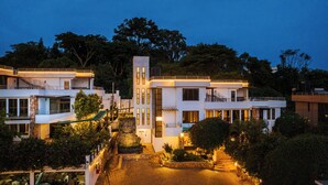 A modern multi-story residential building with a central tower, multiple balconies, and a well-lit courtyard. - Hotel Noesis  (Kampala)
