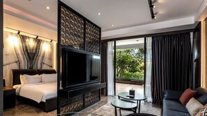 Ein modernes Hotelzimmer mit einem großen Bett, einem Flachbildfernseher, einer Couch, einem kleinen Tisch und einem Balkon mit Vorhängen.