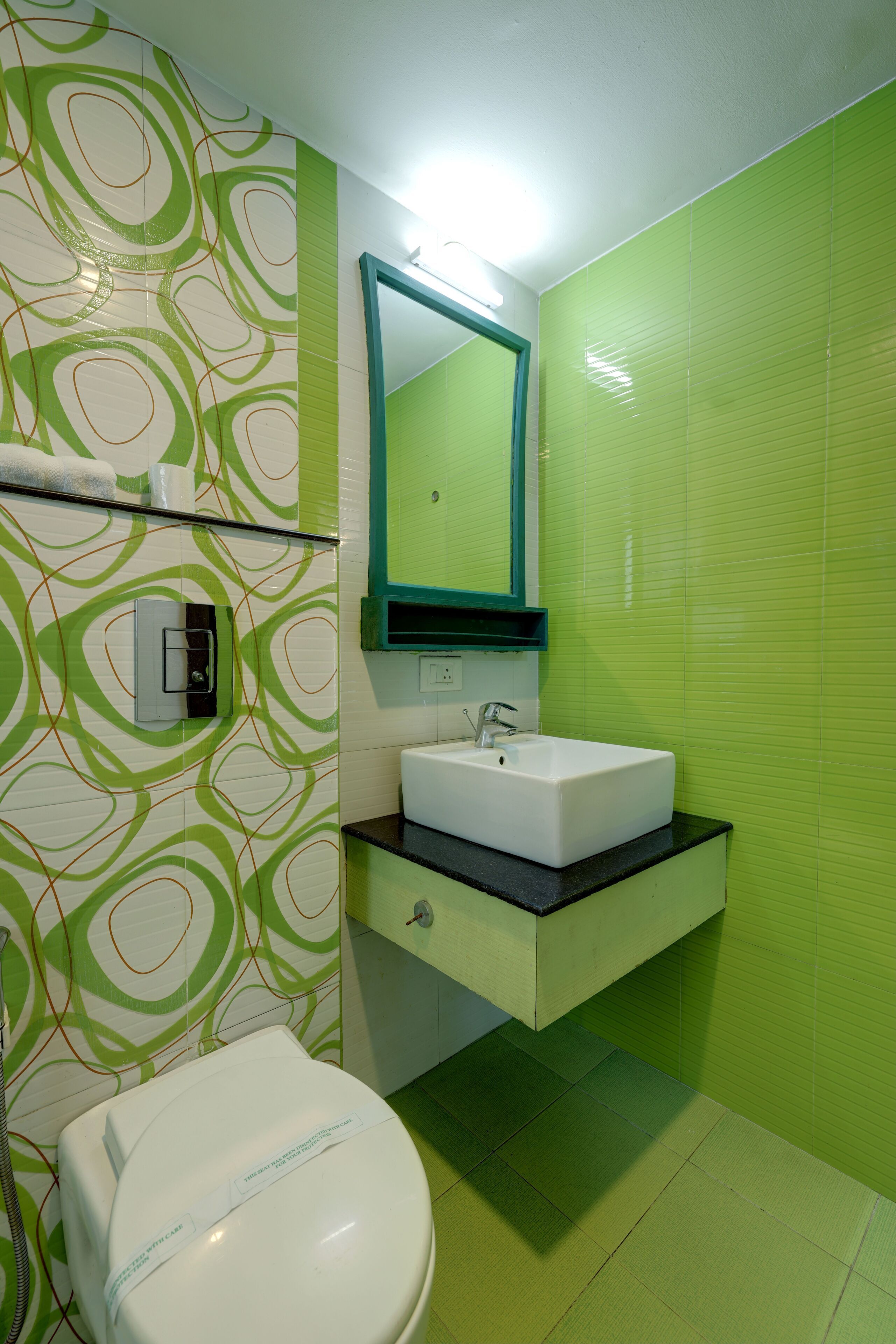 A bathroom with a toilet, sink, and mirror.