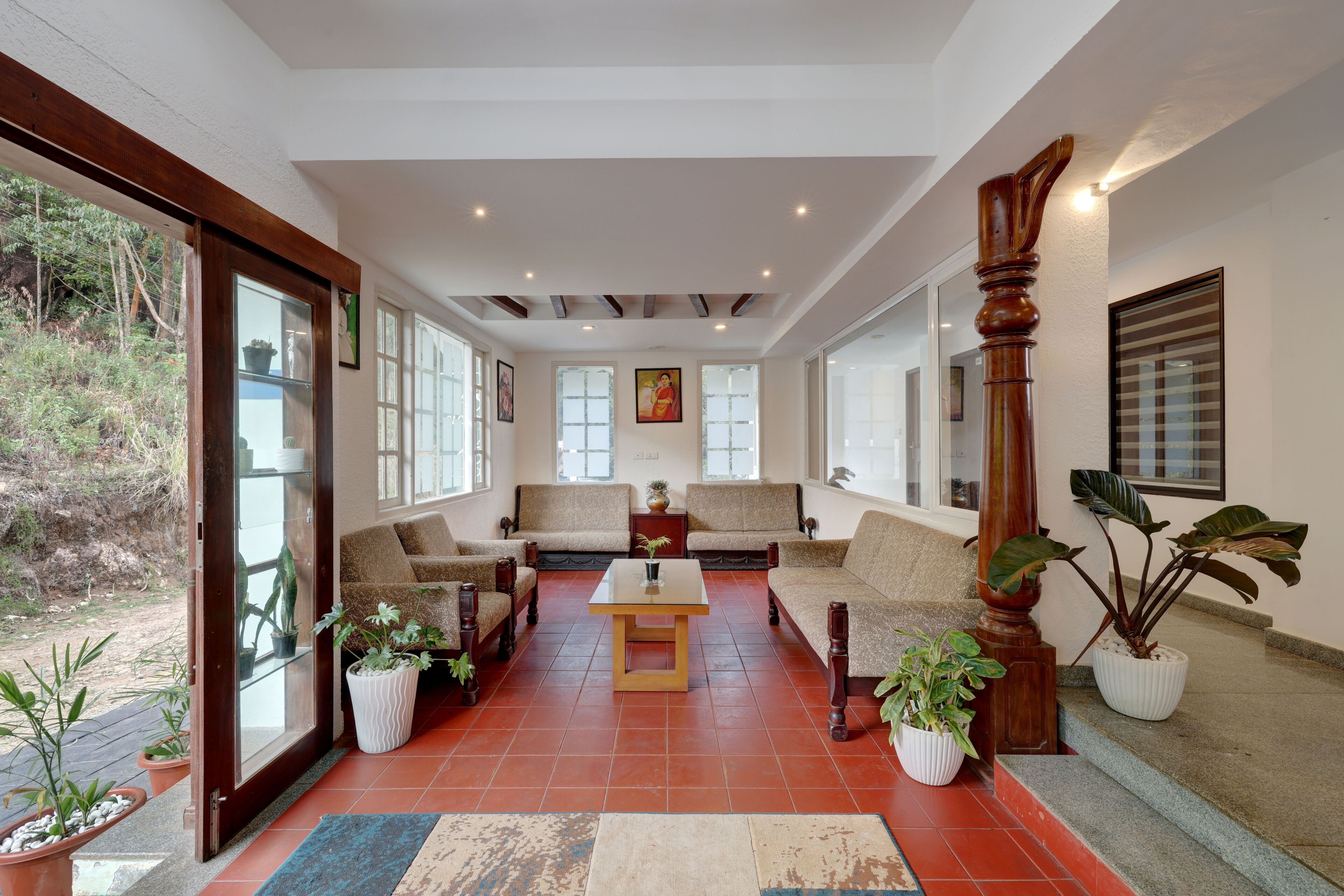 A spacious living area with a large window, a wooden coffee table, and several sofas.