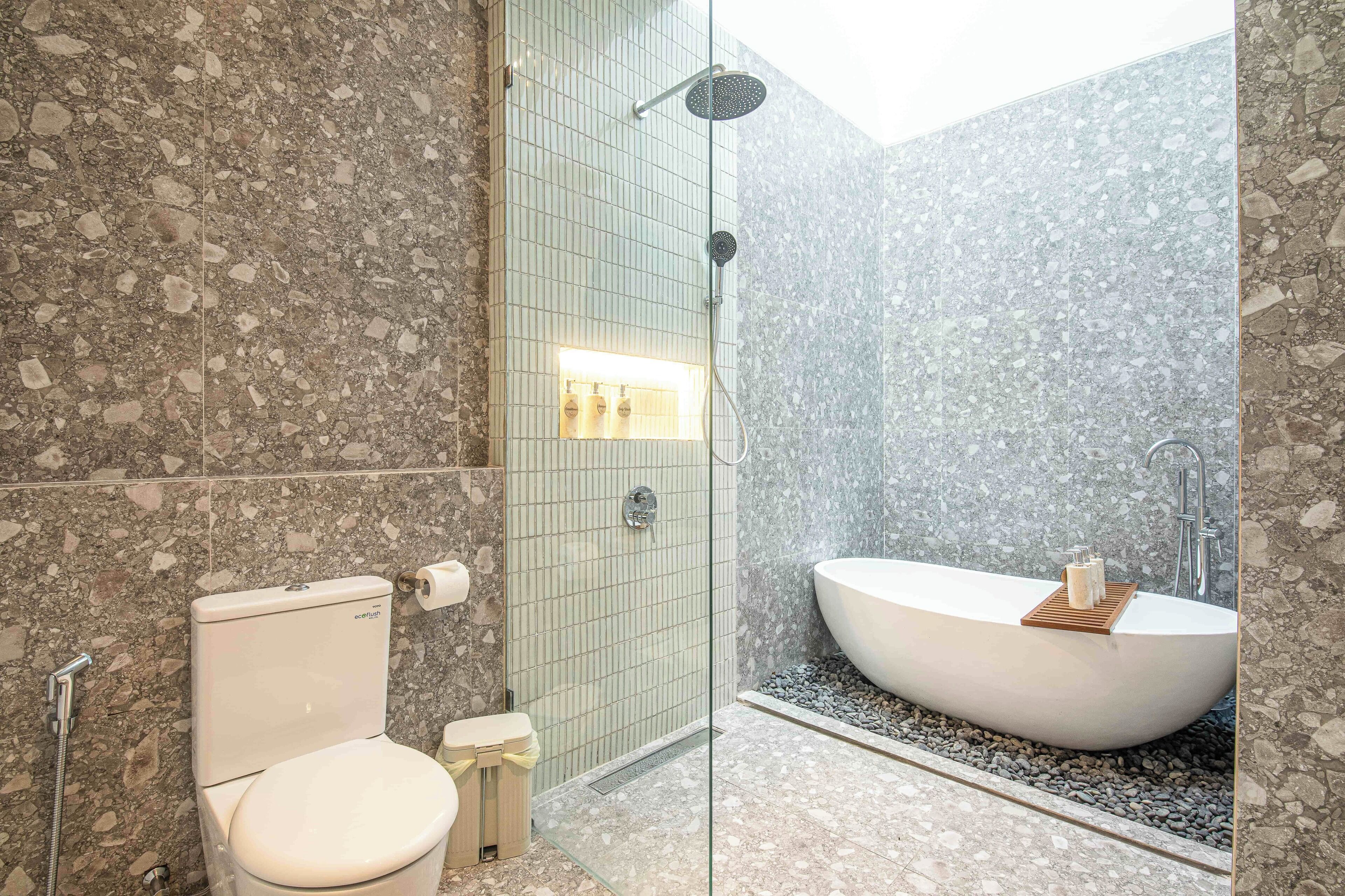 Un baño con una bañera independiente, un inodoro y una zona de ducha.