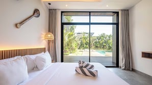 Habitación de hotel con una cama grande, vista a una piscina y cabecera de madera.