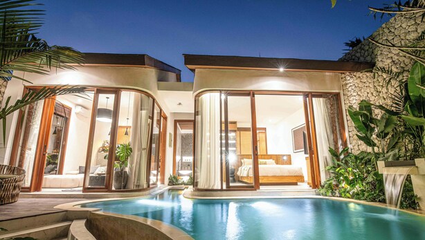 A modern hotel with a swimming pool, large glass doors leading to a bedroom, and a stone wall. - Chic 1BR Villa Jungle Escape Heart of Ubud (Ubud)