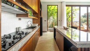 Una cocina moderna con armarios de madera, encimera negra y vistas al exterior.