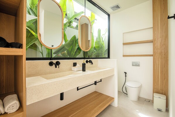 A modern bathroom with a large mirror, two sinks, and a toilet. - Modern 2br Uluwatu Villa 2mins to Beach (Pecatu)
