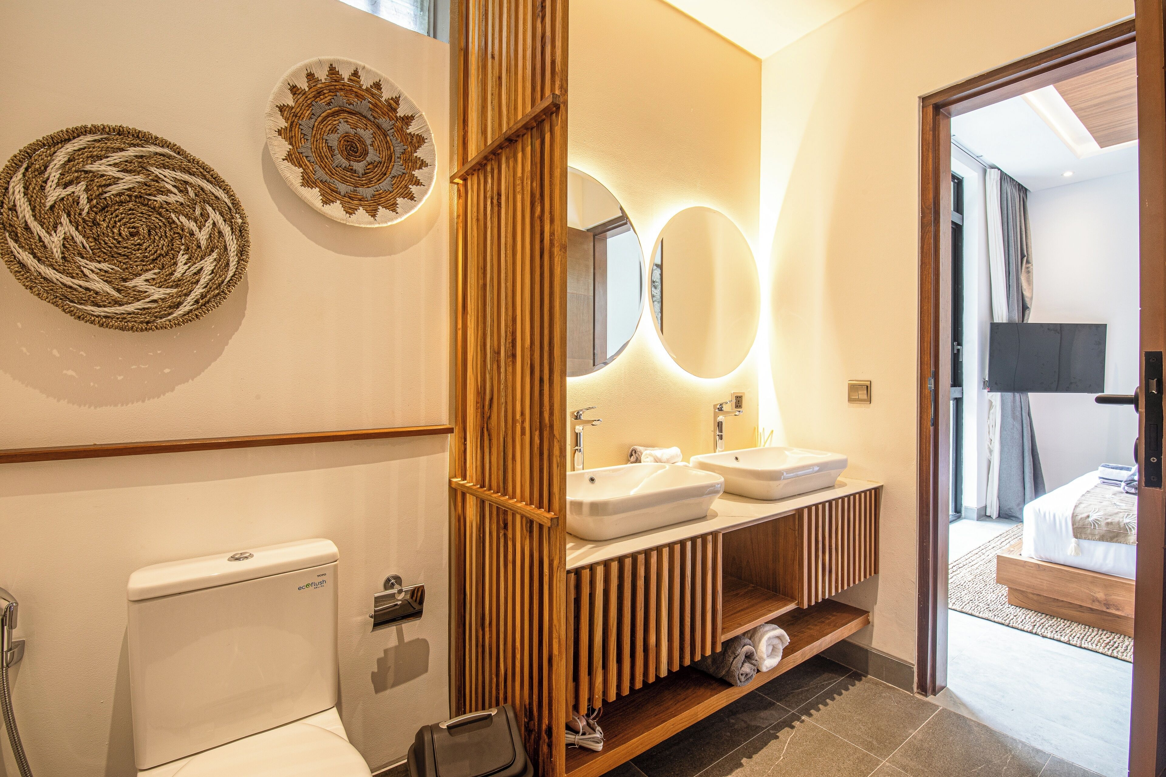 Een moderne badkamer met twee wastafels, een toilet en een douche.