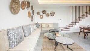Una sala de estar moderna con sofá, mesa de centro y arte decorativo en la pared.