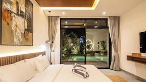 Habitación de hotel moderna con una cama grande, un cuadro en la pared, televisión y vistas a una piscina y jardín a través del ventanal.