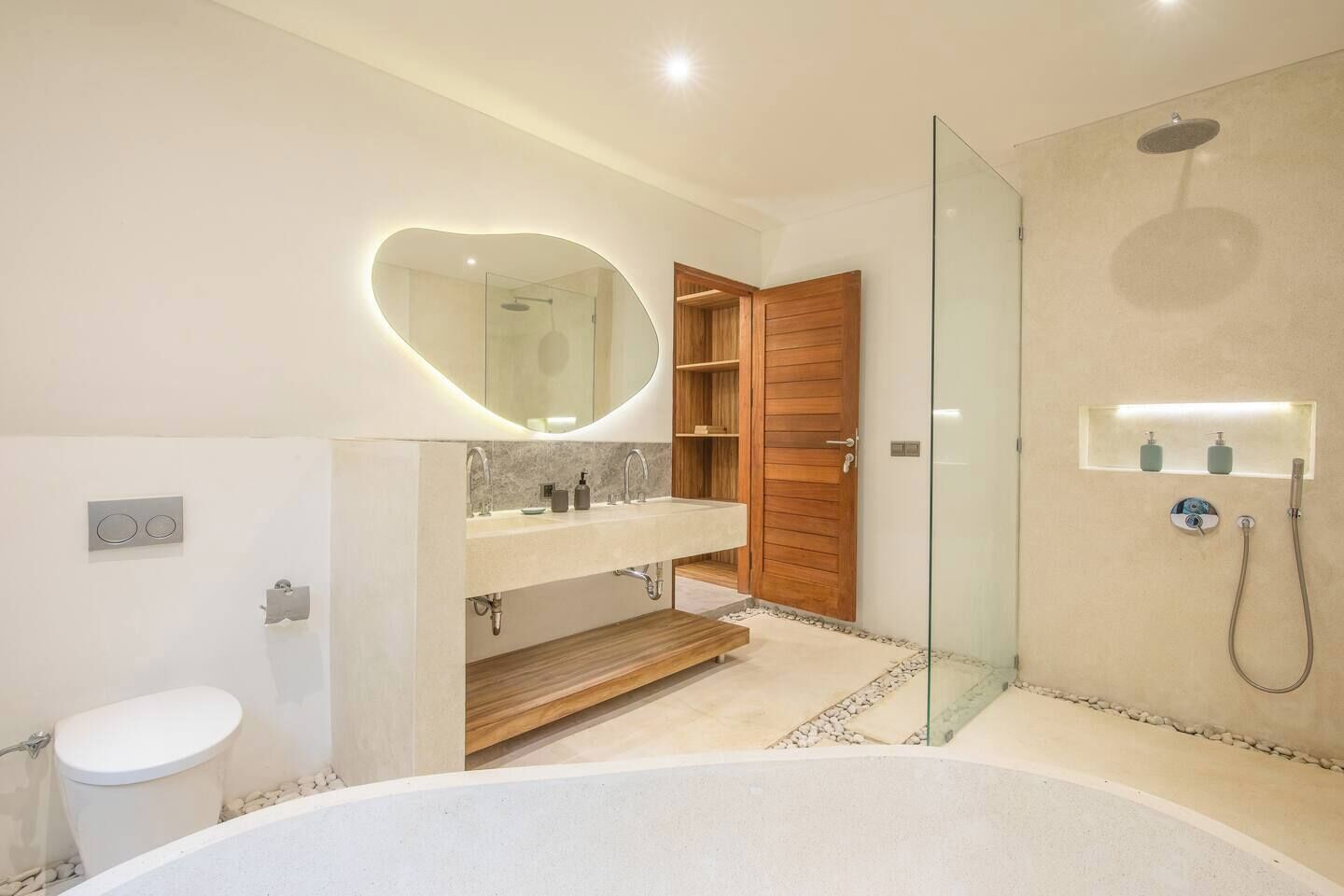 A modern bathroom with a bathtub, a glass-enclosed shower, and a vanity with a mirror.