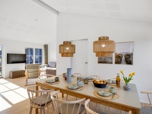 A modern dining area with a long table, chairs, and two hanging light fixtures. - "Eida" - 500m from the sea by Interhome (Løkken)