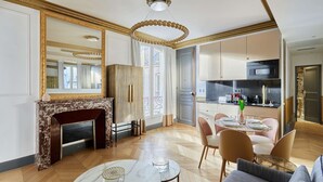Een moderne woonkamer met een open haard, een eethoek en een keuken.
