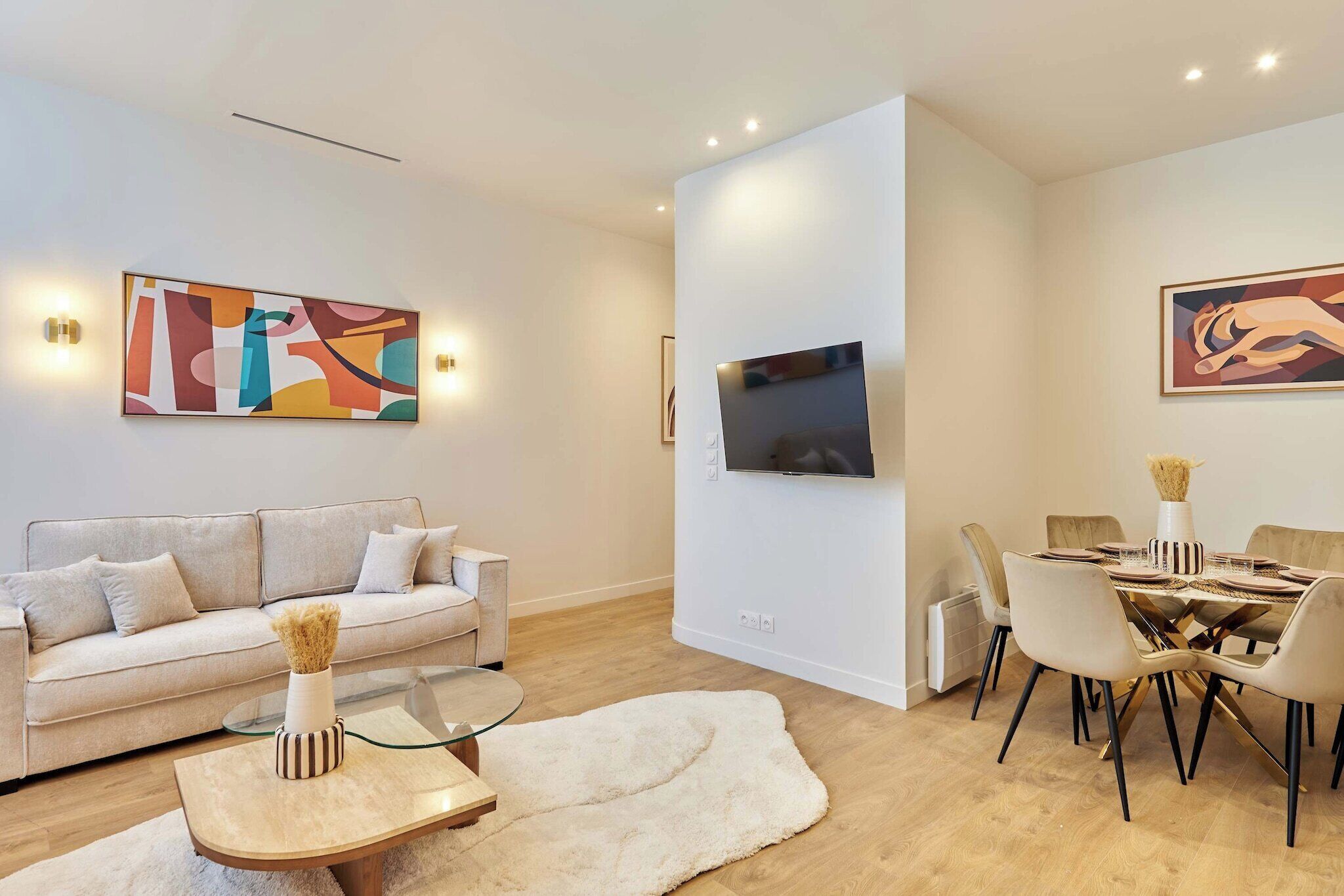 Ein modernes Wohnzimmer mit Sofa, Couchtisch und Essbereich.