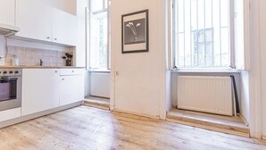 Cucina con mobili bianchi, forno integrato e finestra vista esterna.